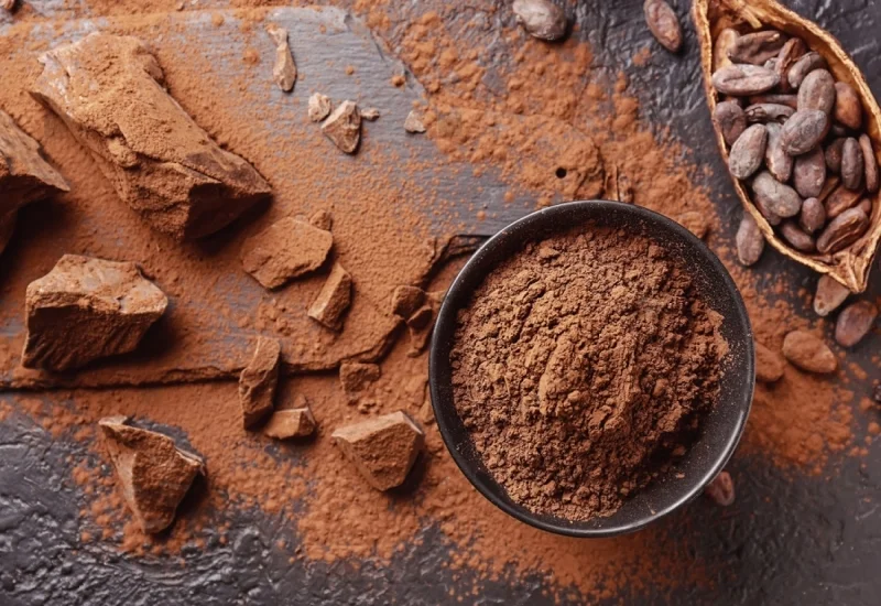 composition with cocoa powder beans and chocolate on table