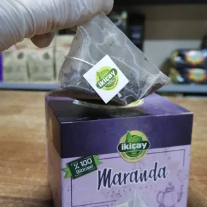 hand holding teabag on top of teabag package